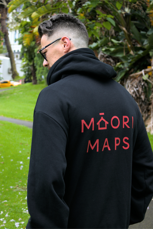 Person wearing a black hoodie with 'Maori Maps' text on the back, standing outdoors.